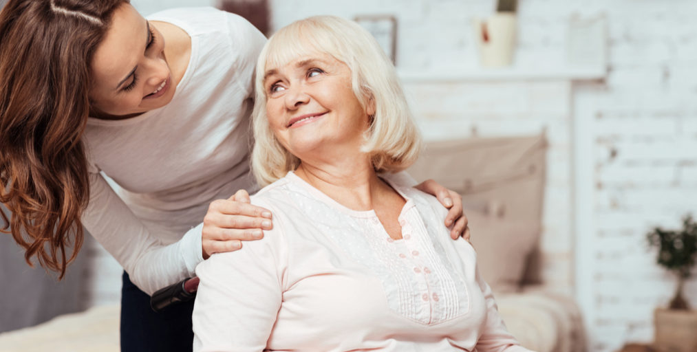 Adult woman and senior woman look at each other fondly